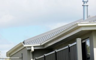 A section of roof with a chimney and gutter.