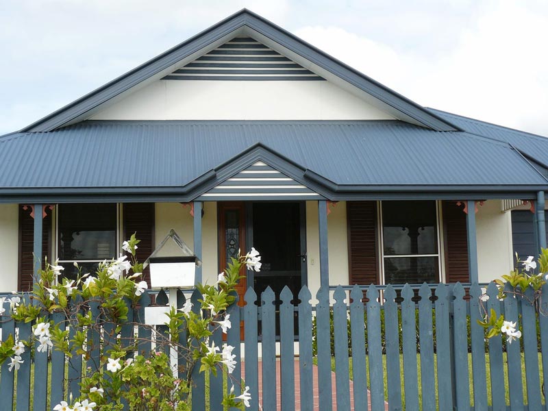 traditional blue roof house with white flowers